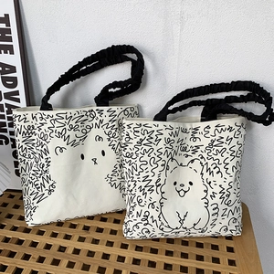Detail of cute hand-drawn cartoon dog pattern on canvas tote with ruffle strap