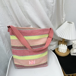 Detailansicht der bunt gestreiften Web-Tasche mit Strukturstoff und Handarbeit-Etikett