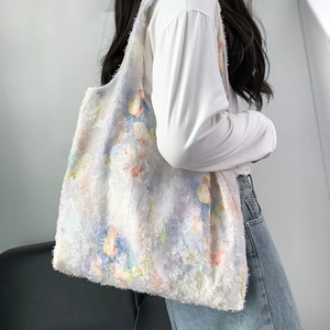 Detailed texture of white fringe canvas tote bag with abstract floral prints worn by model