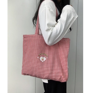 Détail du sac fourre-tout à carreaux rouges et blancs avec imprimé cerise