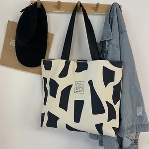 Detail of canvas tote bag with rabbit print and GOOD STUDENT text in lifestyle setting