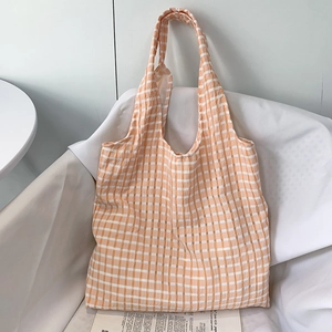 Detail of orange and white checkerboard canvas tote bag with textured cotton fabric