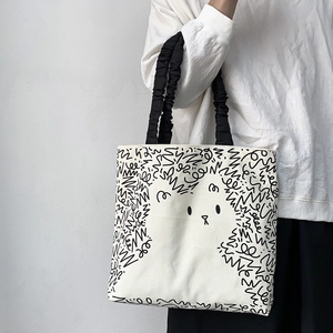 Detail of canvas tote bag with black cartoon animal line art and ruched handles