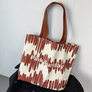 Dettaglio della borsa tote in tela con logo Pink Sunday e manico marrone di grande capacità