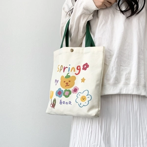 Dettaglio della borsa tote in tela con graziosi motivi di orsi e fiori primaverili