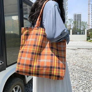 Détail du grand sac cabas à carreaux orange montrant sa capacité et sa texture en toile