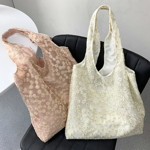 Detailed embroidery of white daisies on pink and beige organza shoulder tote bags