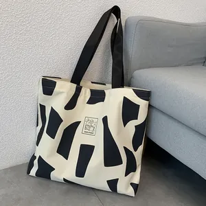Detail of canvas tote bag with black geometric print and Good Student rabbit label