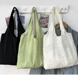 Detailed texture of leaf pattern jacquard fabric on three colorful summer tote bags