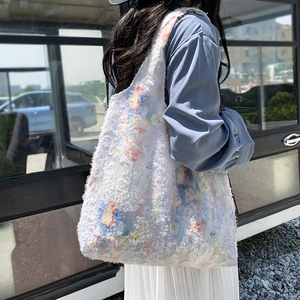 Outdoor shot of a large floral tote bag with fringe texture and colorful flower patterns