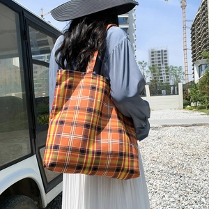 Photo en extérieur d'un grand sac cabas à carreaux orange au design élégant et spacieux