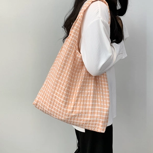 Detail of the orange and white checkered canvas tote bag showing the fabric texture
