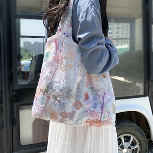 Artistic tote bag with 3D floral embroidery in pastel colors shown on shoulder