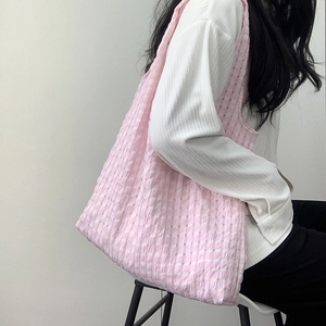 Detail of pink and white checkered seersucker tote bag showing textured fabric and capacity