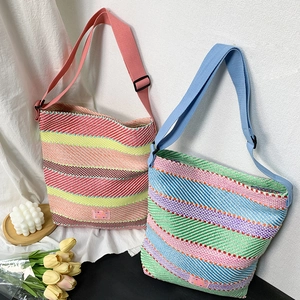 Detail von farbenfrohen gestreiften Web-Tote-Bags mit Herz-Label und weicher Textur
