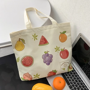 Detail of canvas tote bag with fruit prints and Happiness Comes From Within label