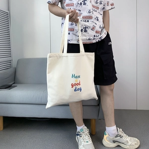 Detail of minimalist cream canvas tote bag with Have a good day text print on shoulder strap
