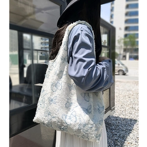Detailed view of the frayed edge texture and blue butterfly pattern on a canvas tote bag