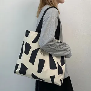 Minimalist canvas tote bag with black geometric patterns and Good Student label on strap