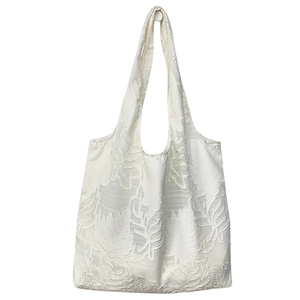 Minimalist white tote bag with textured leaf patterns and integrated shoulder straps