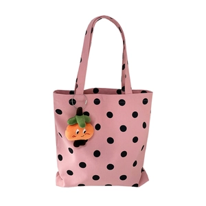 Pink polka dot canvas tote bag with orange plush charm and spacious zipper closure