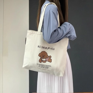 Vue détaillée du sac cabas en toile blanche avec imprimé chiot et anses renforcées