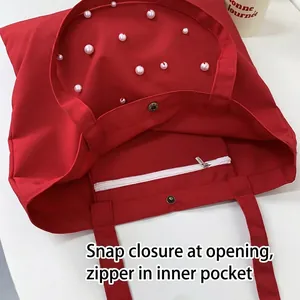 Minimalist red canvas tote bag with white pearl accents and internal zipper pocket
