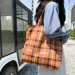 Détail du sac cabas en toile à carreaux orange montrant le tissu texturé et sa capacité
