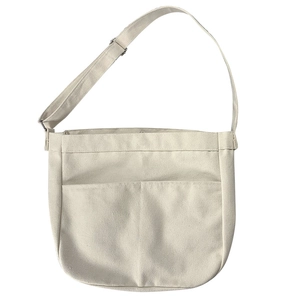 Minimalist beige canvas crossbody bag for women featuring adjustable wide straps and pockets