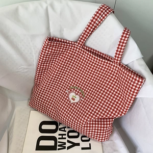 Vue détaillée du sac cabas à carreaux rouges et blancs avec logo cœur et cerises