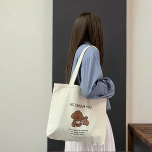 Détail du sac fourre-tout en toile blanche avec motif caniche marron et texte anglais