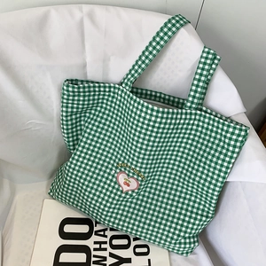 Détail de la broderie cerise sur le sac cabas en toile à carreaux verts et blancs