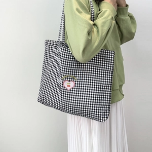 Gros plan du sac fourre-tout en toile à carreaux noir et blanc avec imprimé cerise