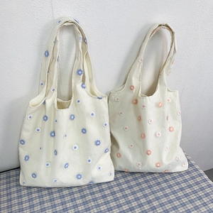 Broderie florale détaillée sur sacs fourre-tout en toile aux accents bleus et oranges