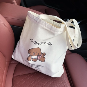 Détail du sac fourre-tout en toile blanche avec motif chien sur siège de voiture