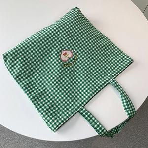Détail du cabas en toile à carreaux verts avec broderie cerise en cœur et logo Sweet Cherry