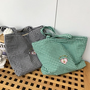 Détail des sacs cabas en toile avec broderie cerise et motif à carreaux élégant