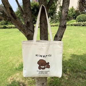 Détail du sac cabas en toile crème avec illustration de caniche et texte doux