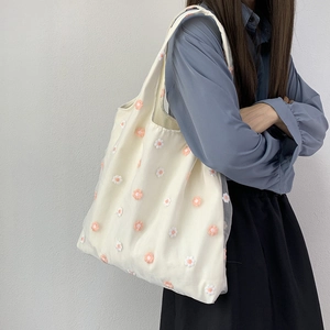 Gros plan de la broderie florale sur un sac fourre-tout en toile crème