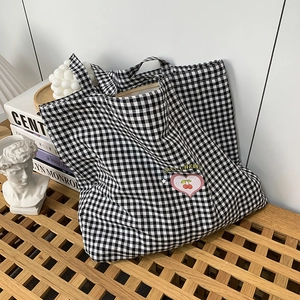 Gros plan sur le sac en toile à carreaux noir et blanc avec broderie cœur et cerise