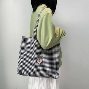 Gros plan du sac fourre-tout en toile à carreaux noirs et blancs avec imprimé cerise