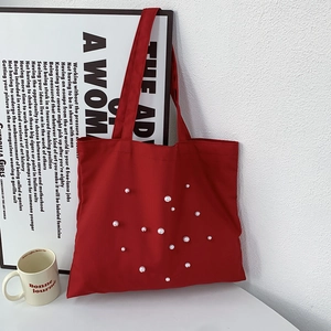 Red canvas tote bag with white faux pearl embellishments and durable double handles