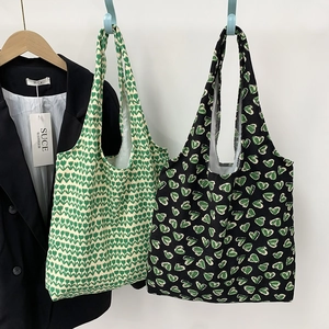 Detailed shot of tulip and heart print canvas tote bags hanging in a casual setting