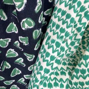 Detailed close-up showing soft corduroy textures and green heart patterns of the shoulder bag