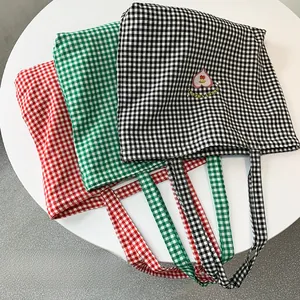 Trois sacs cabas en toile à carreaux avec broderie Sweet Cherry sur une table blanche