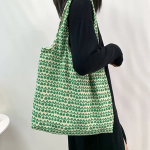 Knitted shoulder tote bag with green tulip wave patterns on cream white fabric