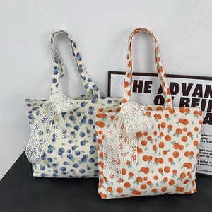 Floral canvas tote bags with blueberry and orange prints and decorative lace bows