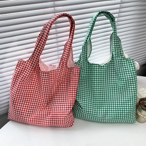Dettaglio di grandi borse tote in tela con motivi a scacchi vintage rossi e verdi