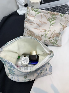 Detail of floral makeup bag featuring ATRYG label and organized skincare items