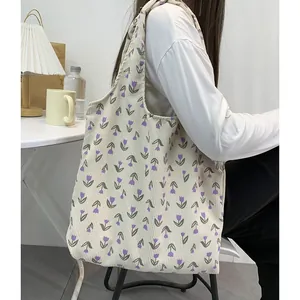 Detail of beige corduroy tote bag featuring purple tulip pattern and soft texture